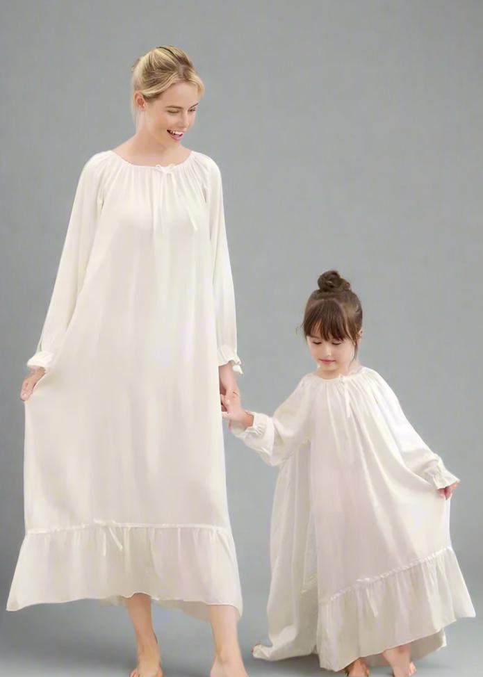 Mother and daughter in matching white long nightgowns with ruffle accents