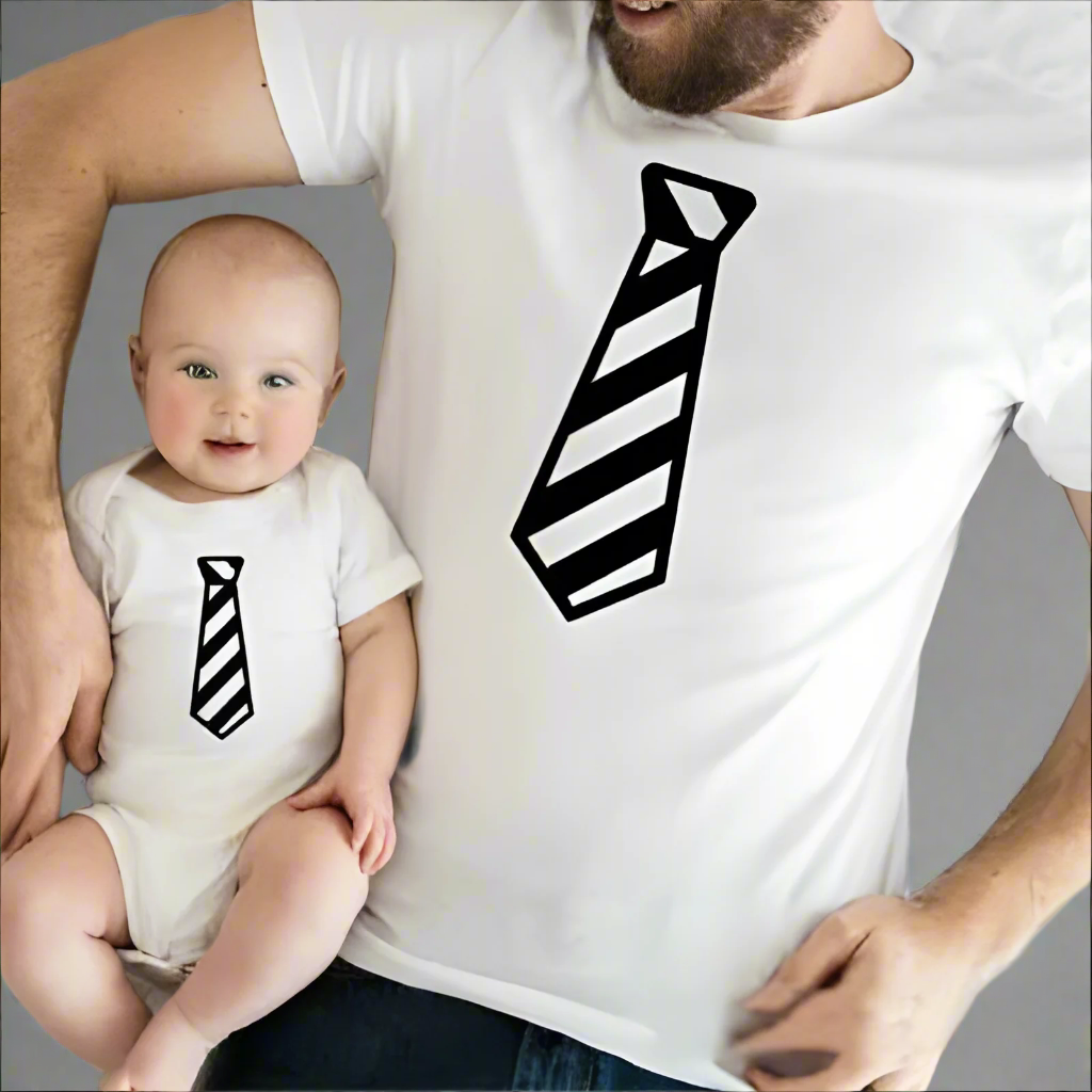 Father and child wearing matching tie-print shirts, black shirts with white striped tie design