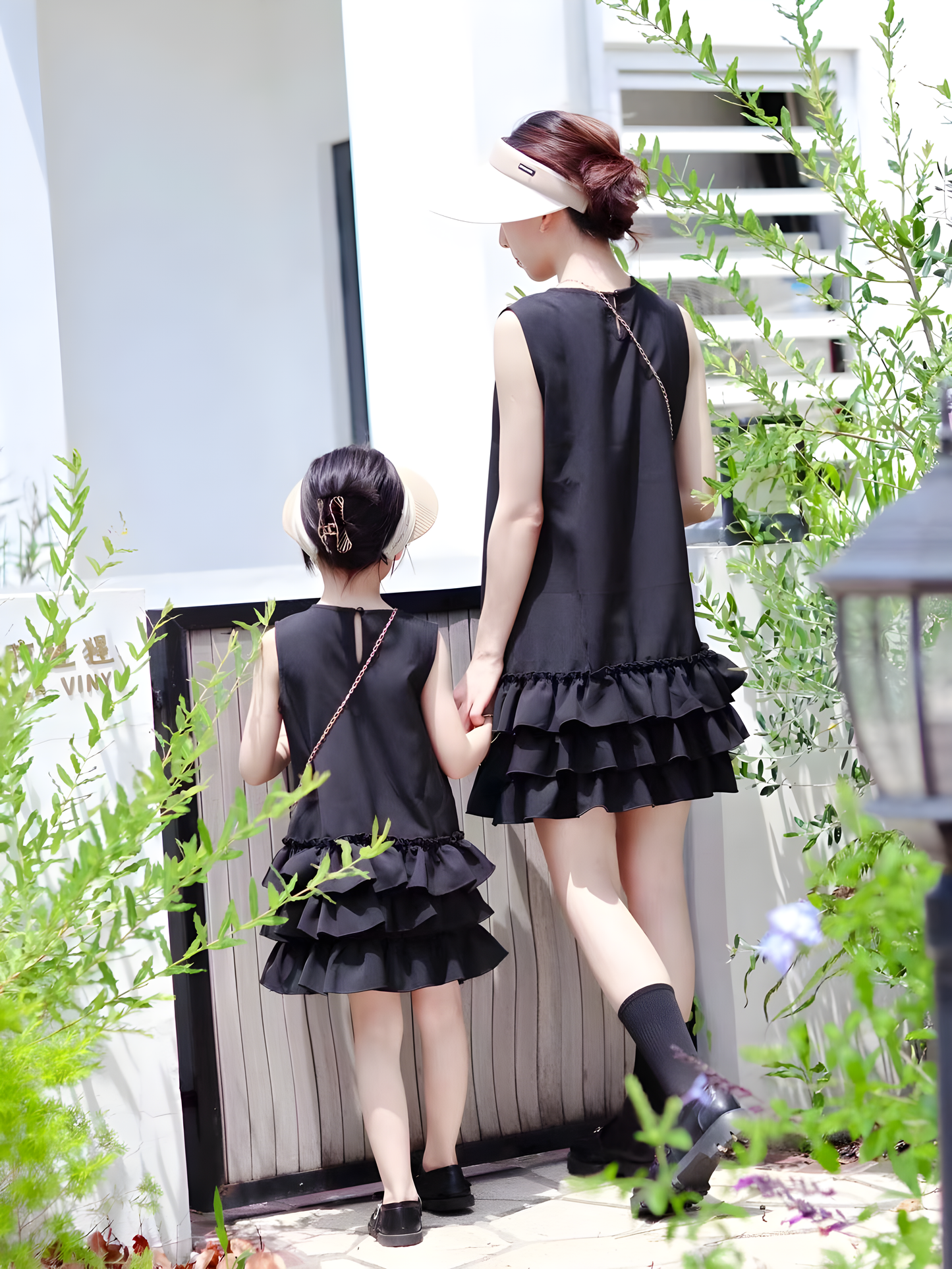 Elegant matching black ruffle dresses for mother and daughter with chain purses