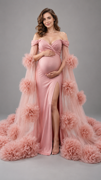 Pregnant woman in a dusty pink maternity gown with a sheer floral tulle cape in a photo studio