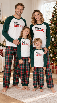 Family in matching white and green raglan We are Family pajama tops, worn with green and red plaid pants.