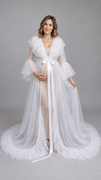 Pregnant woman in a white sheer tulle ruffle-collar maternity gown in a photo studio