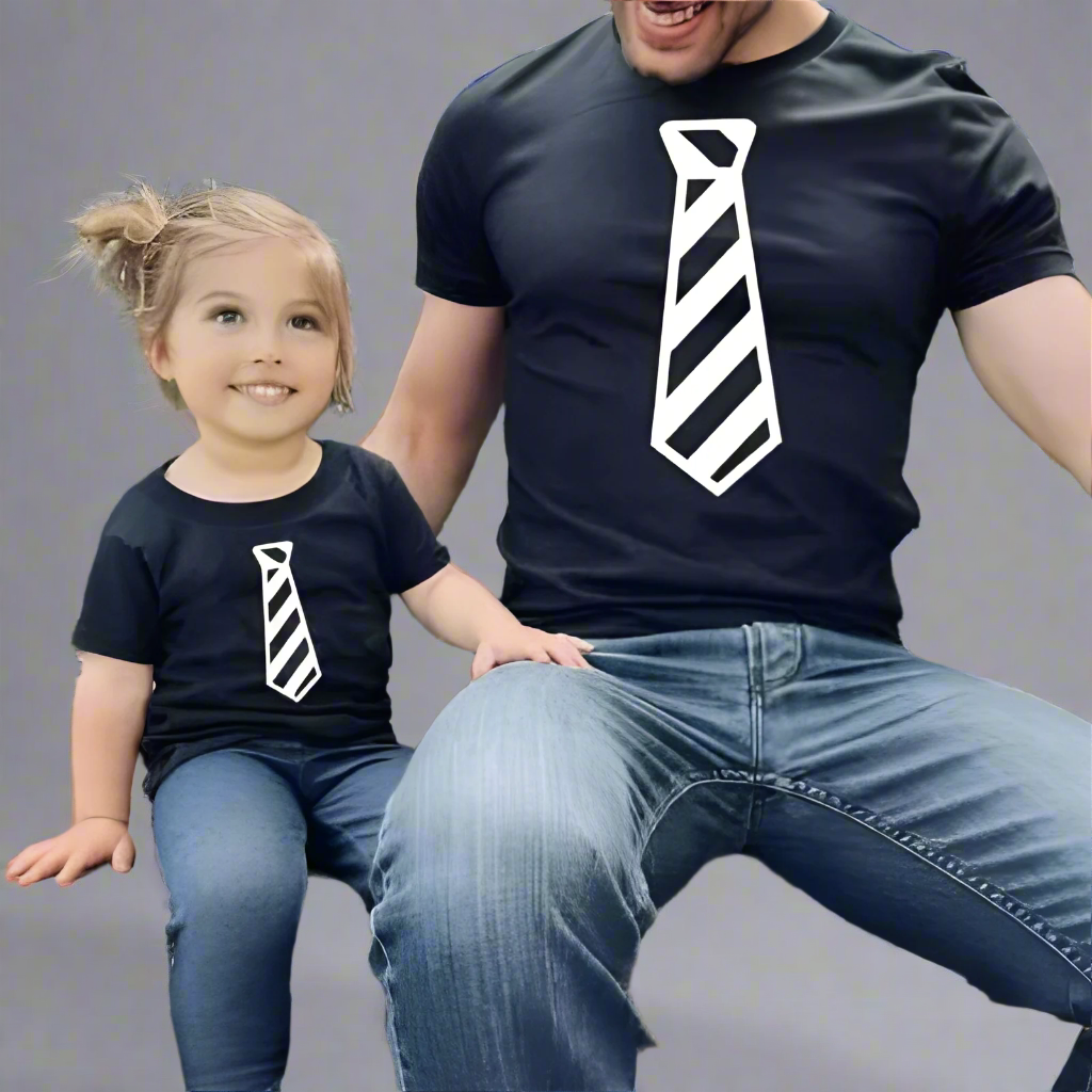 Dad and baby wearing matching tie-themed shirts, white shirts with striped tie print