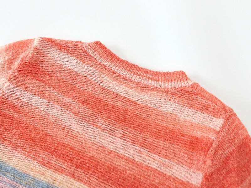 Warm family matching striped sweaters in soft coral, blue, and yellow tones