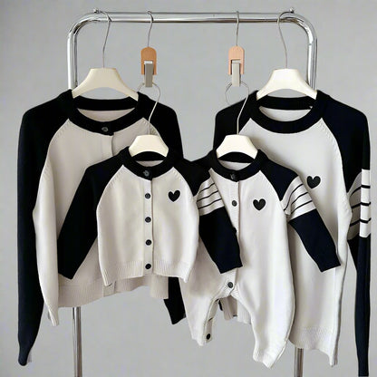 Family knit cardigans with cream body, heart motif, and contrasting sleeves in red and black