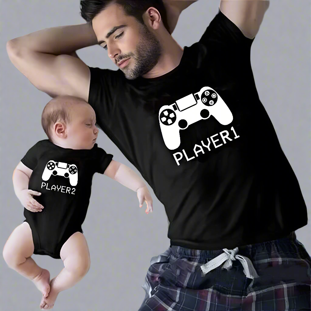 Father and baby wearing matching 'Player 1' and 'Player 2' gaming T-shirts