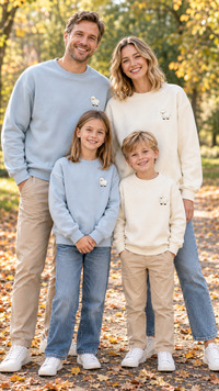 Family in matching light blue crewneck sweatshirts with a small white lamb patch on the chest.