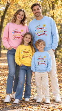 Family in matching sweatshirts printed with the words Make Life Sweet, a little sun, bunting and cherries.
