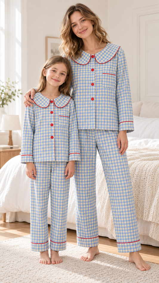 Mom and daughter in matching blue gingham button-up velvet pajamas with red-piped Peter Pan collars.