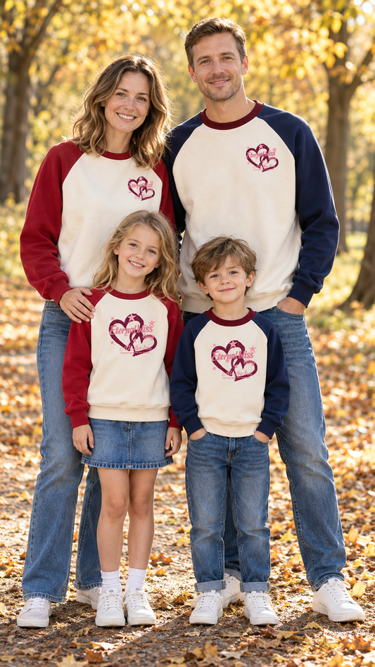 Family in matching cream raglan sweatshirts with navy or red sleeves and two outlined hearts with Eternal bliss script.