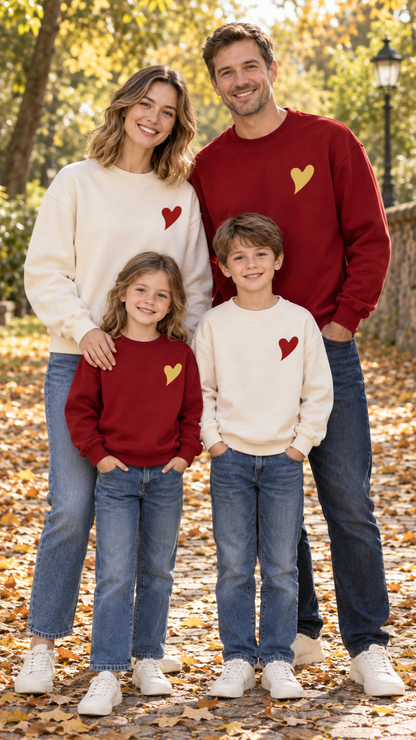Family in matching burgundy crewneck sweatshirts with a small gold heart on the chest.