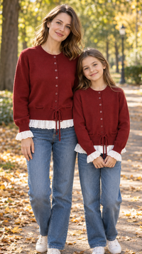 Mom and daughter in matching burgundy knit cardigans with white lace ruffle cuffs and hems.