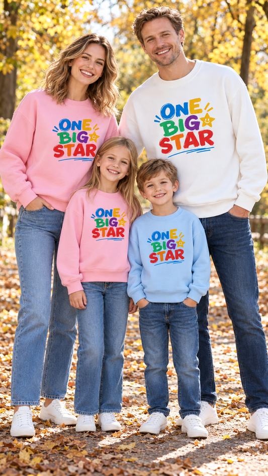 Family in matching sweatshirts printed ONE BIG STAR in chunky rainbow letters.