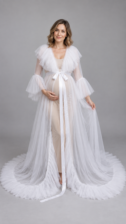 Pregnant woman in a white sheer tulle ruffle-collar maternity gown in a photo studio