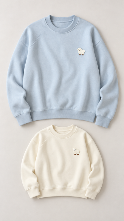 Little Lamb matching sweatshirts for an adult and a child, laid out without models.