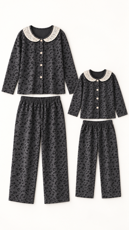 Charcoal Leopard Lace matching Christmas pajama sets for an adult and a child, laid out without models.