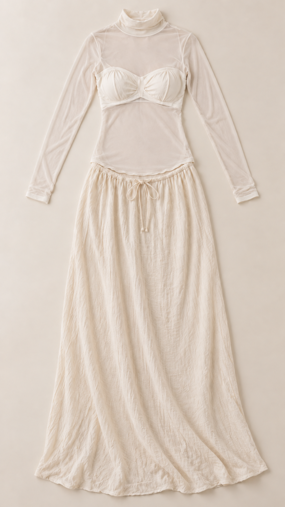 Cream maternity photoshoot set with sheer mock-neck top, bustier and drawstring maxi skirt on a dress form