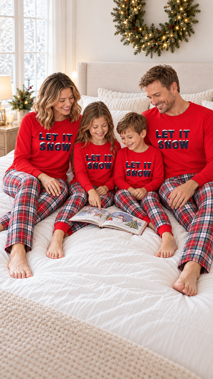 Family relaxing together at home in matching Let It Snow Christmas pajamas.