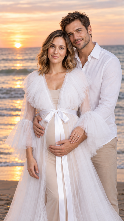 Expecting mother in a white sheer tulle maternity gown with her partner