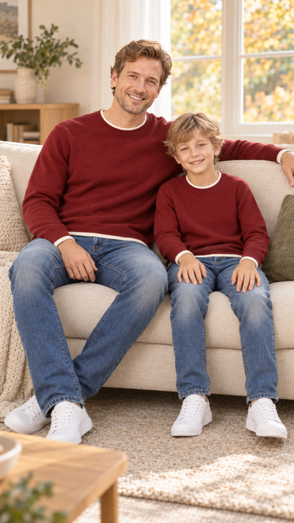 Dad and son relaxing together at home in matching Burgundy Trim Crew knit sweaters.