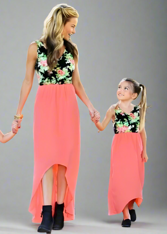 Matching coral high-low dresses with floral tops for mother and daughter, perfect for family photos