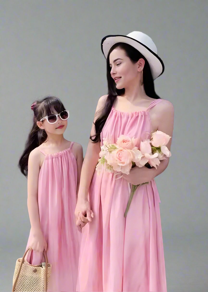 Mother and daughter in matching pink sundresses holding flowers
