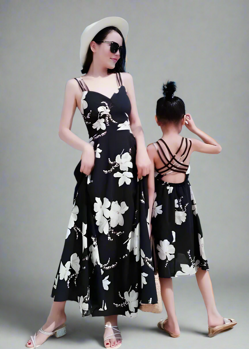 Mommy and me matching black floral sundresses at the beach