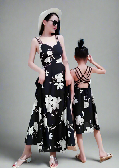 Mommy and me matching black floral sundresses at the beach