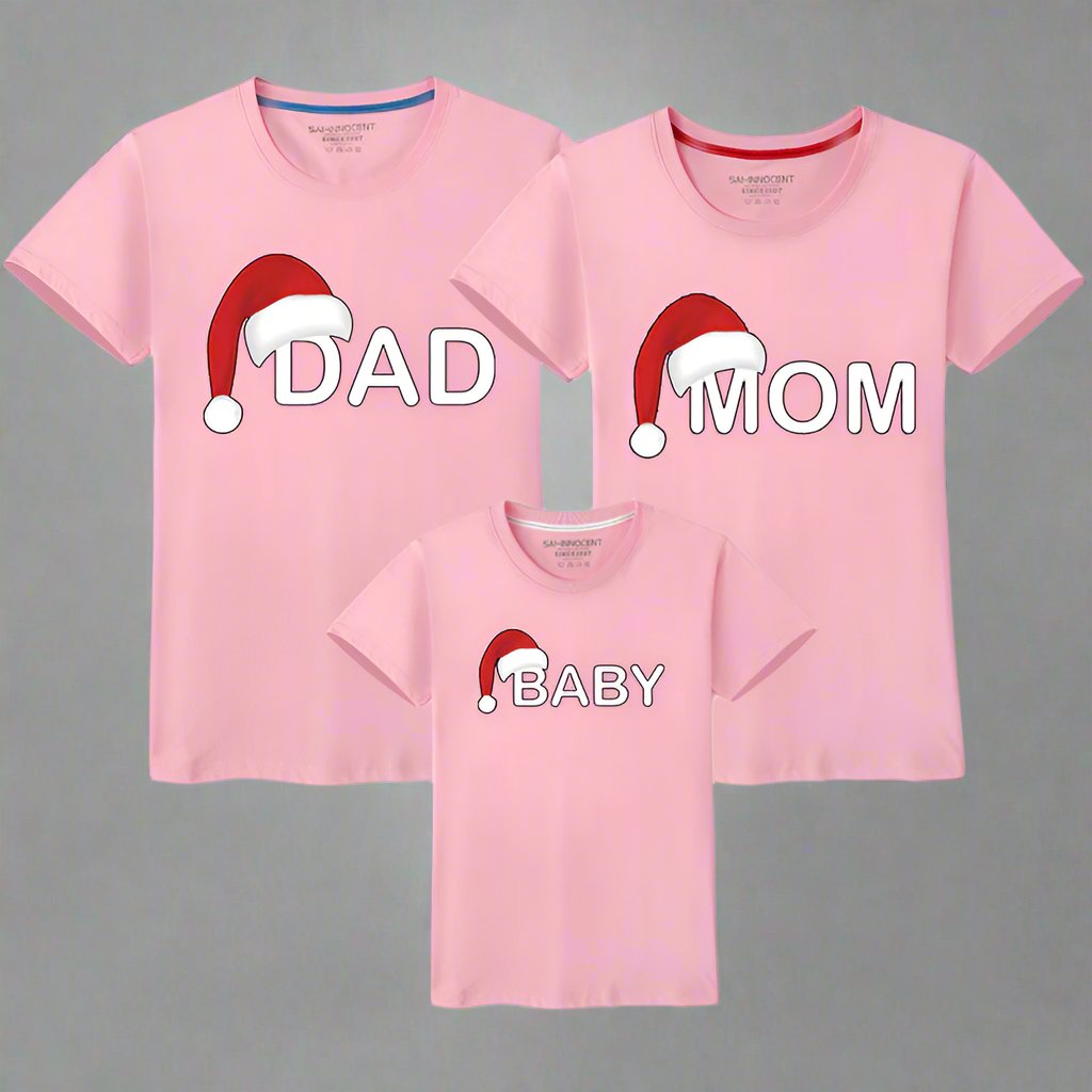Pink matching family shirts for Christmas with festive Santa hat design and text for Dad, Mom, and Baby