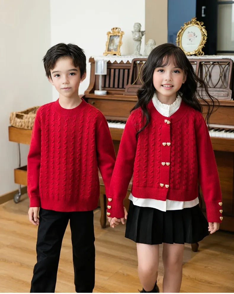 Brother and sister in matching red cable knit sweaters, posing together in a cozy family outfit style