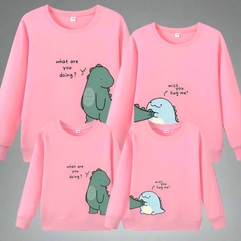 Matching family sweaters with cute dinosaur print saying 'What are you doing?' in pastel colors