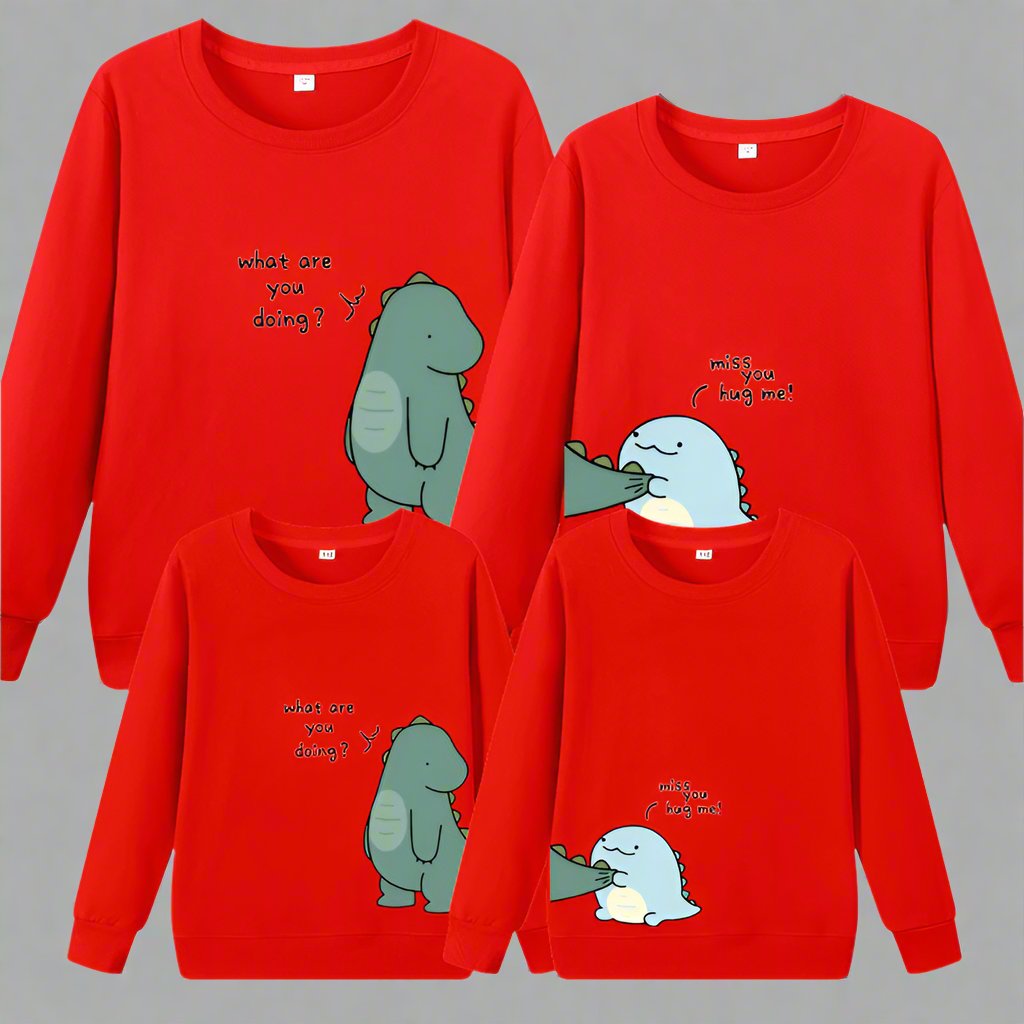 Mom, dad, and child matching dinosaur sweaters with 'Miss You, Hug Me' and 'What Are You Doing?' prints